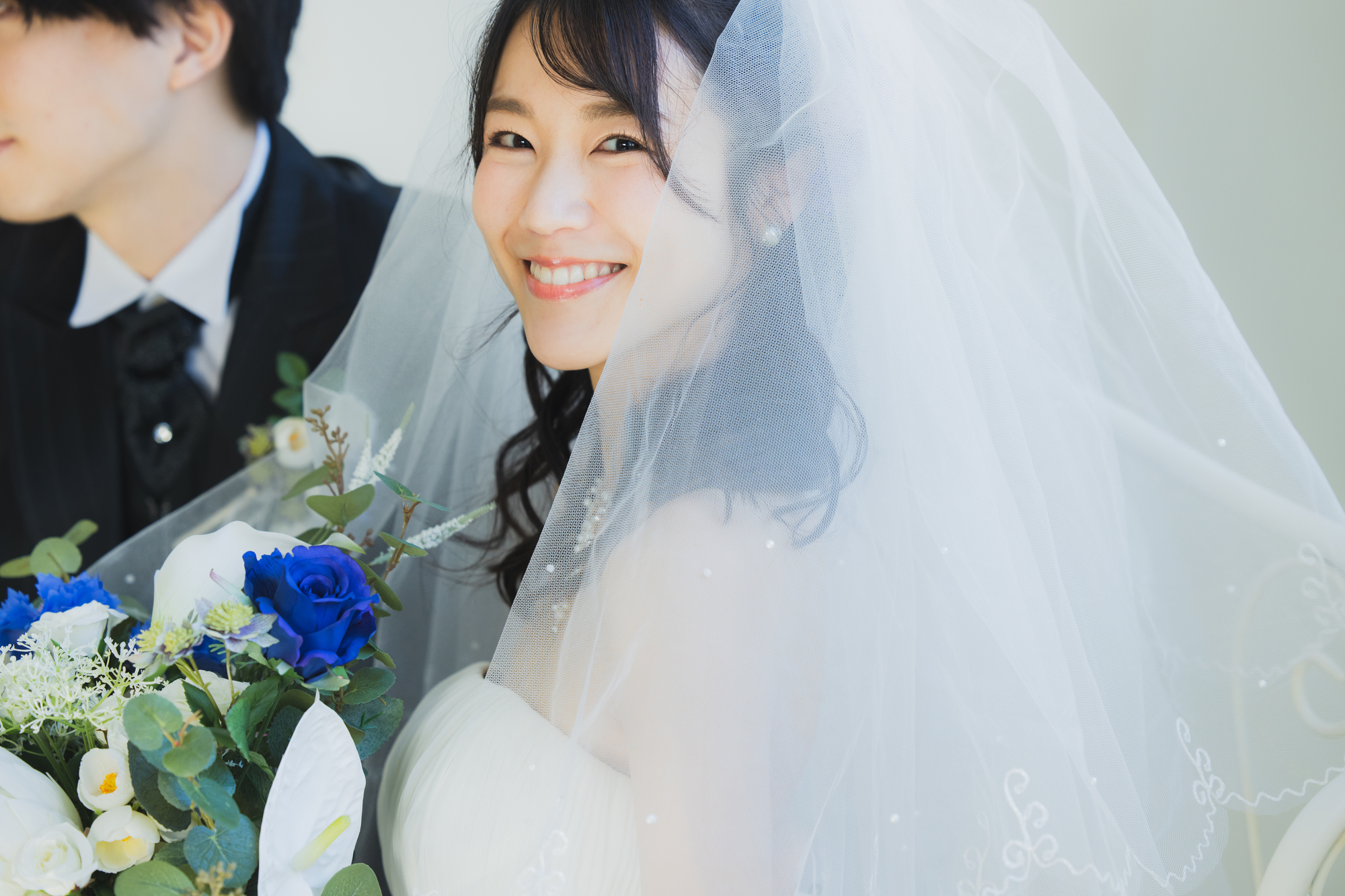 ブーケを手に微笑む花嫁と新郎